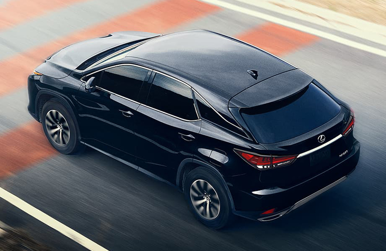 Black 2020 Lexus RX viewed from a raised angle as it drives up a city street.