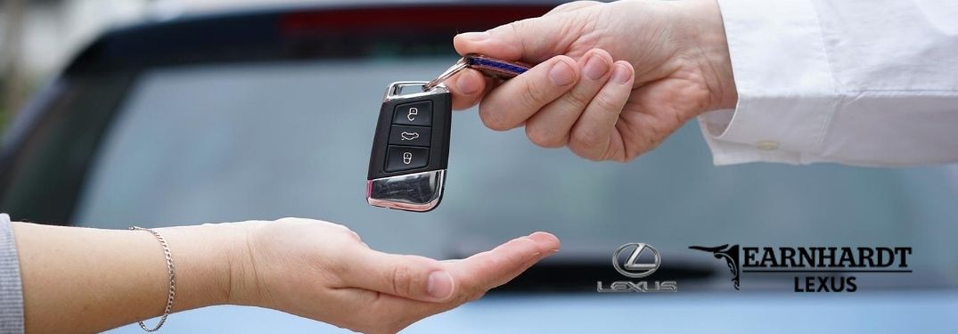 Close Up of Man Handing Keys to a Woman with Earnhardt Lexus Logo in Lower Right Corner
