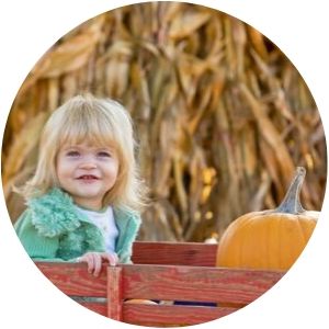 Girl Sitting in a Wagon with a Pumpkin