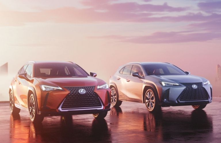 Orange and Silver 2021 Lexus UX Hybrid Models in a Parking Lot at Sunset