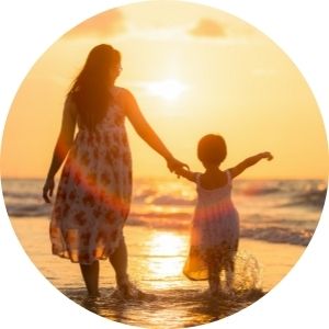 Mother and Daughter Walking on a Beach at Sunset