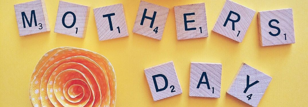 Scrabble Tiles Spell Mother's Day on Yellow Background