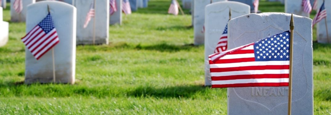 Headstones in a Cemetery with American Flags