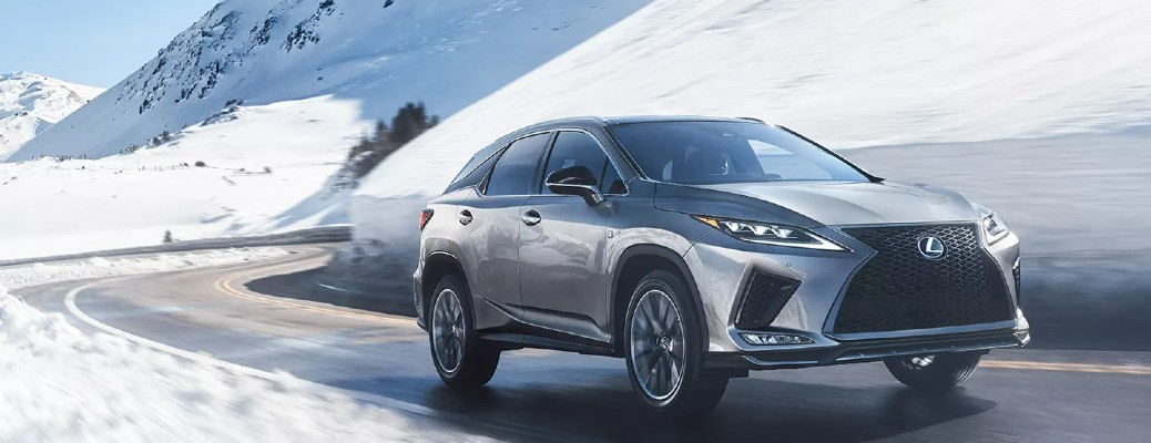 A 2022 Lexus RX 350 driving down a snow lined road.