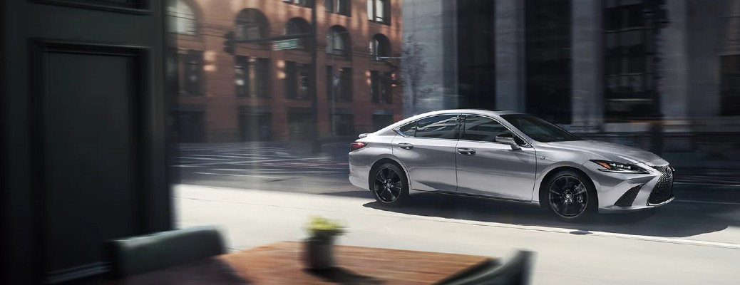 A 2022 Lexus ES class car driving past a cafe window, as seen from in the cafe