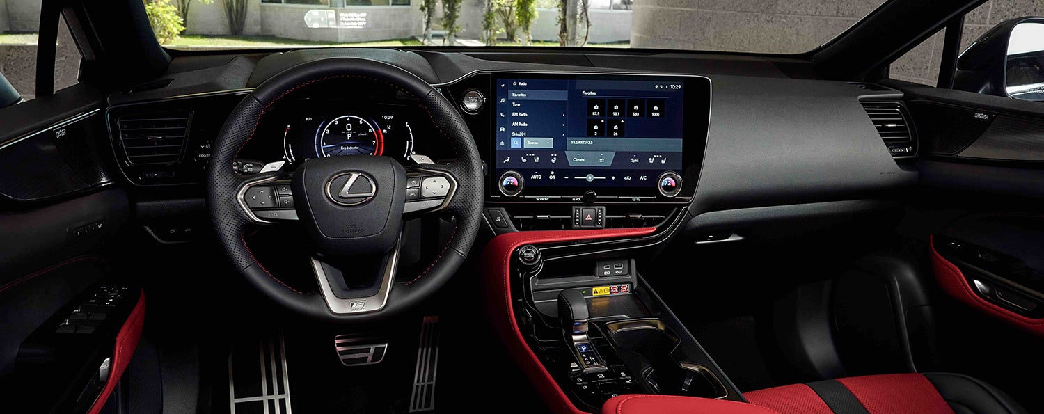 The interior of a Lexus car, showing the steering wheel, digital dashboard, and a large central touchscreen display.