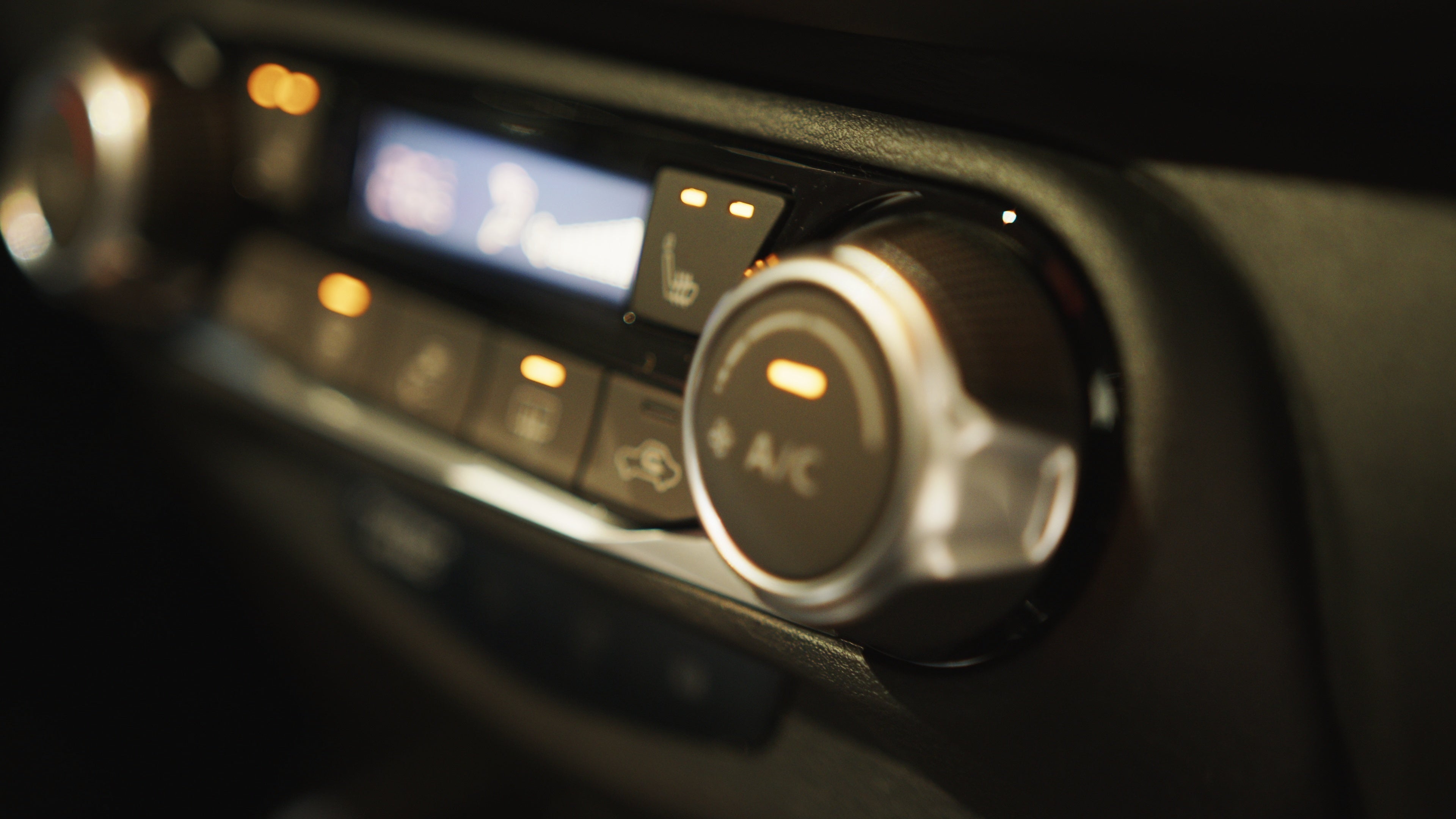 Modern car climate control panel for driver and passenger with shallow depth of field.