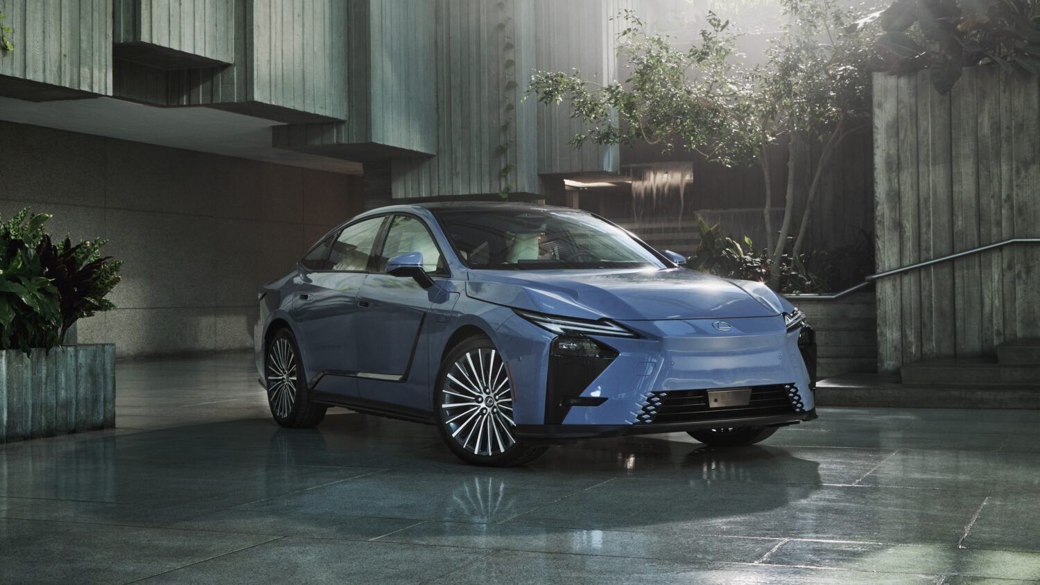 A light blue 2026 Lexus ES 350e in Phoenix is parked facing the viewer to the right in the lobby of a modern building.